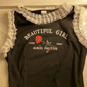 Svart topp med vitt volang, och en ros - Super snygg topp, den är Andvänd 2 gånger)