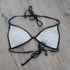 Bikiniöverdel - Grå vadderad bikinitopp från HM. Det är bruna fläckar från sand på insidan. Lappen är bortklippt men det är nog strl S/36/A-cup