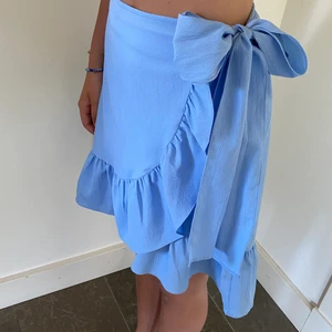 Sommarkjol - Superfin klarblå kjol med knyte på sidan. Jättefint skick. Passar xs-m då man kan justera och knyta så som man vill ha den.