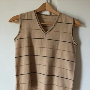 Finstickad Väst/ linne - Beige finstickad väst/linne med ränder, köpt på second hand men inte fått användning av den. Den har ett litet hål på baksidan (se bild 3) annars jättefin!