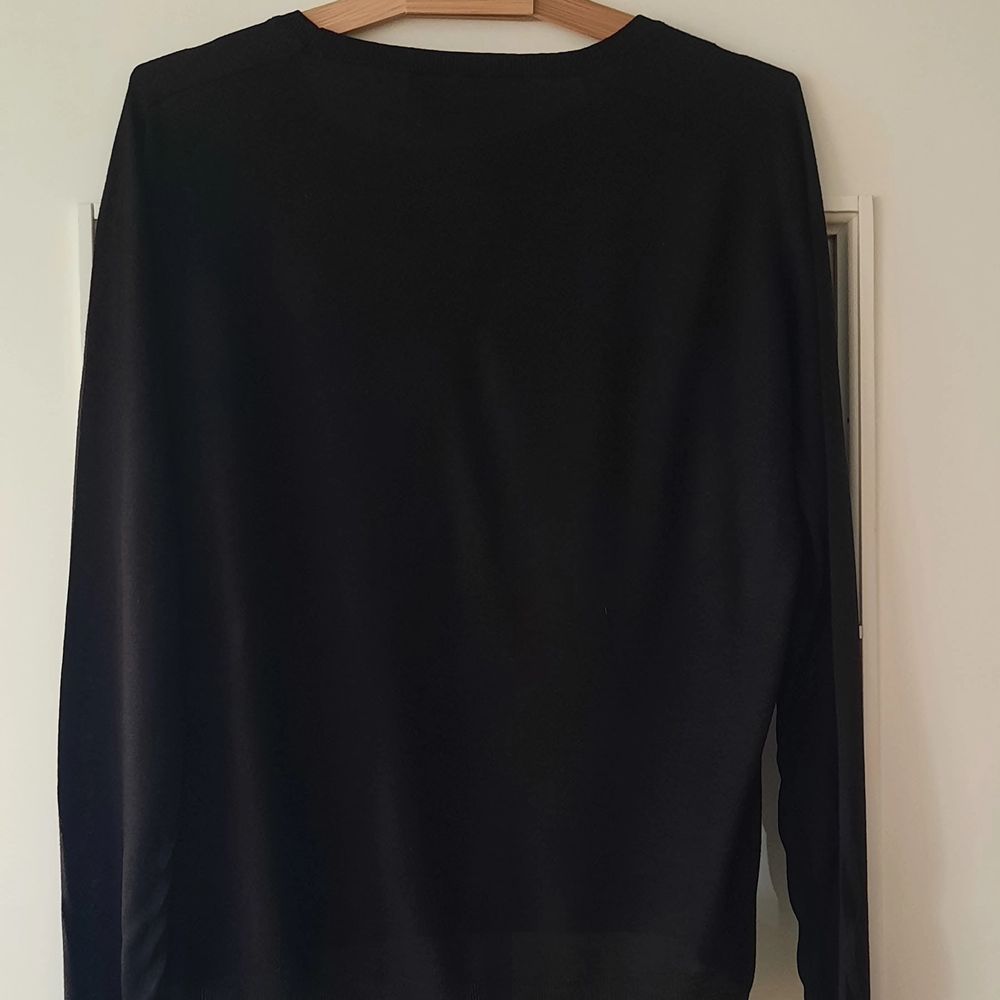 I normally wear S/M and it fits perfectly loose then!:) black soft sweater with golden shoulder detail. 50% acrylic, 50% viscose. Tröjor & Koftor.