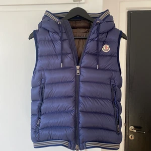 Moncler väst - Sjukt snygg blå moncler väst med luva i storlek 1, slutsåld överallt, inga defekter, givetvis äkta. Sitter sjukt bra, passar dig som är upp mot 175 cm. Dessvärre inget kvitto. Fler frågor är det bara att skriva!👊💕