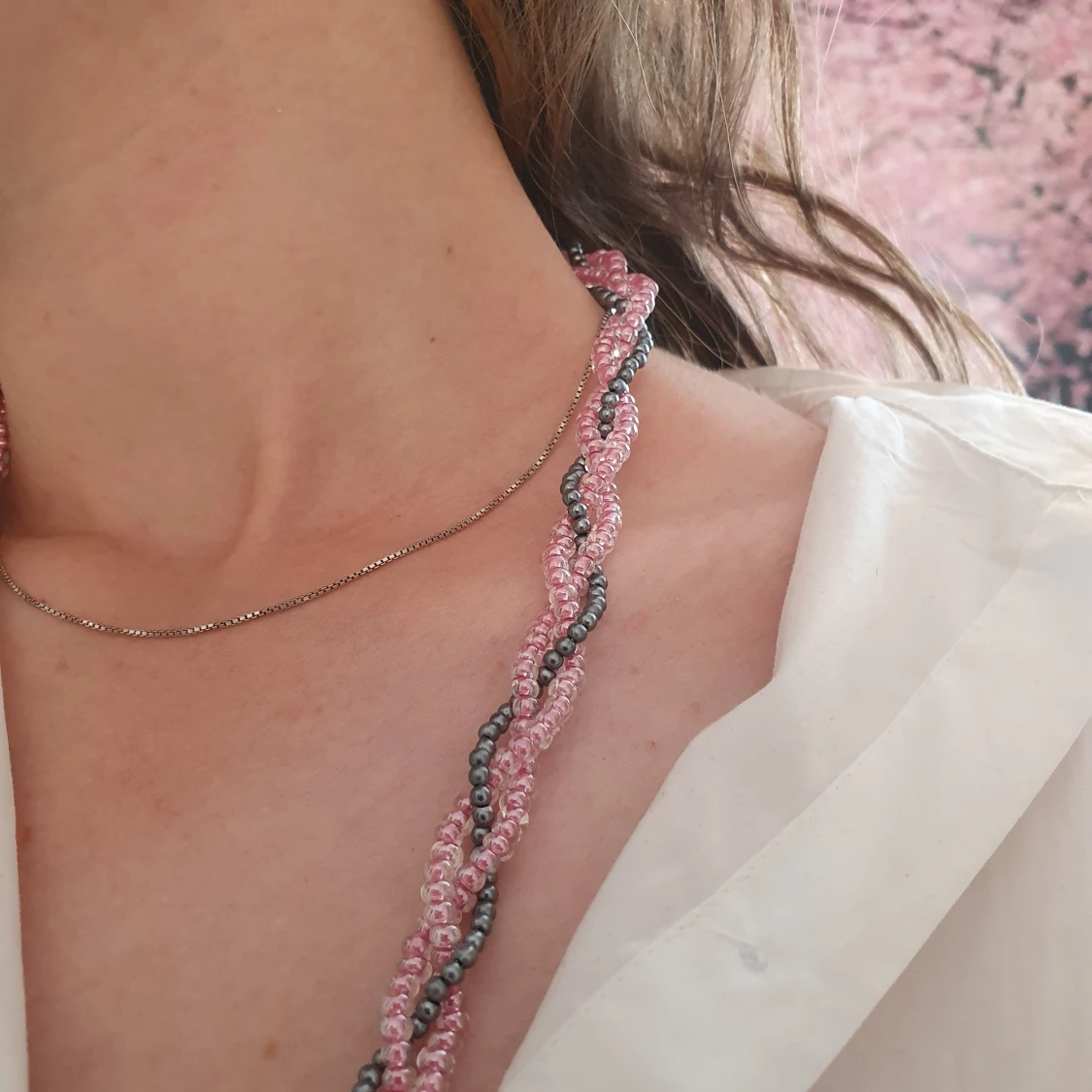 Ett flätat pärlhalsband i rosa och grått. - 90