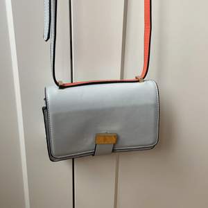 Väska från Zara i ljusblå färg med orange/röda detaljer. Använd 1 gång. 