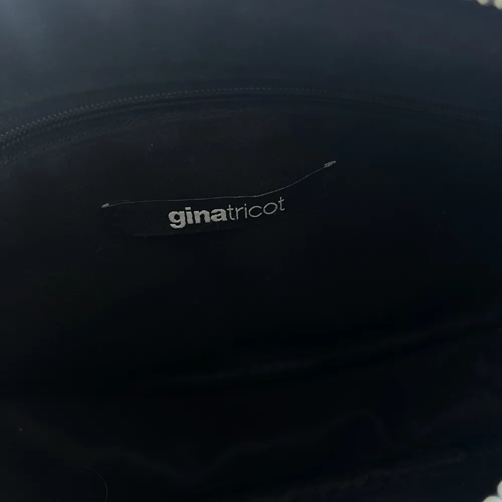 En svart väska i fint skick från Gina Tricot. Den är i lackliknande material på utsidan. Finns inga fläckar eller liknande på insidan . Accessoarer.