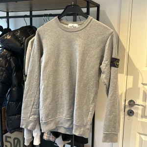 Stone Island sweatshirt - Grå stone Island sweatshirt i okej skick, lite solblekt som ni kan se på patch annars inga flaws. Storlek S, nypris på ca 2300. Bara o skriva vid frågor och funderingar!