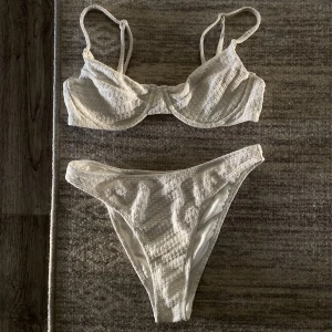Vit mönstrad bikini från Nakd - Säljer denna vita bikinin från NA-KD, knappt använd! Överdel är strl 75B och underdelen är i strl Xs