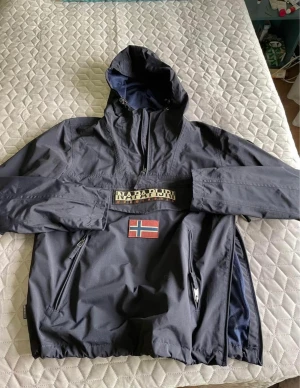 Napapijiri jacka mörkblå - Jag säljer min Napapijiri jacka eftersom den är i bra skick och jag har använt den ett få tal gånger, Priset kan diskuteras, Jag köpte den för 3000kr, Den passar även L.