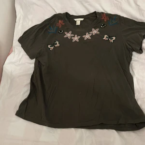 T-shirt - En T-shirt med broderier och ditsyda pärlor av hm