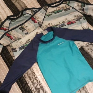 3 UV tröjor barn - 2 likadana med bilmotiv, 1 i storlek 80, 1 i storlek 86. 1 tröja i blå/grön från polarnOpyret i storlek 86-92. Använt skick