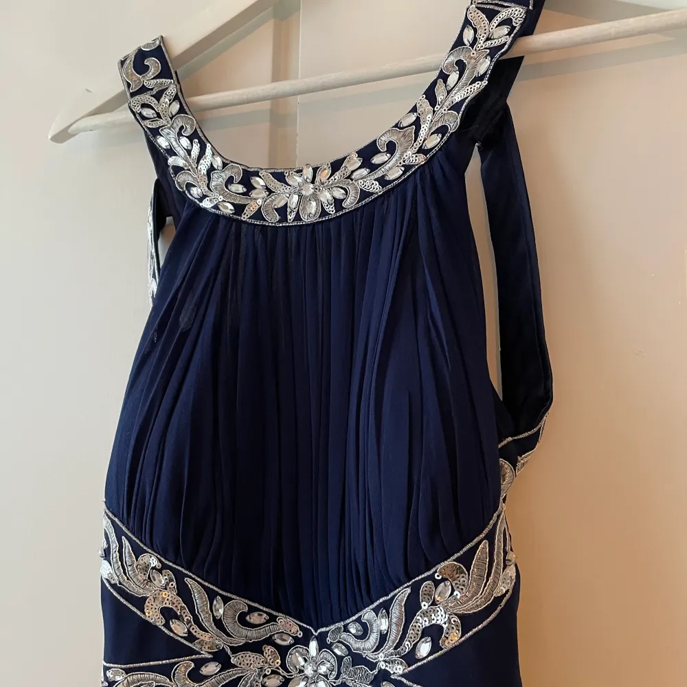Mörkblå balklänning med öppen rygg och fina detaljer. Gott skick, sparsamt använd. Uppsydd: ca 141-142cm lång från axlarna. . Klänningar.