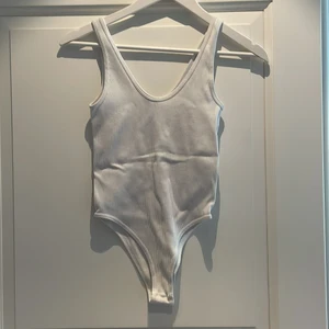 Vit body - Vit body från Zara i strl M-L. Stretch i materialet, ribbat. Vädligt skön! Frakt ingår ej i priset💖