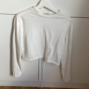 Vit sweatshirt - Vit sweatshirt från Nelly som går att knyta längst ner. Storlek S men passar även XS Frakt tillkommer