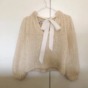 Ganni Julliard sweater - 🌟SÄNKT PRIS!🌟Julliard sweater från GANNI. Köpt second hand krympt, har dock lyckats få den tillbaka till ca original storlek genom att försiktigt handtvätta den. Material: ull & alpacka. Ljus fläck på rosetten, syns knappt (kan skicka bild). Dyr i inköp.