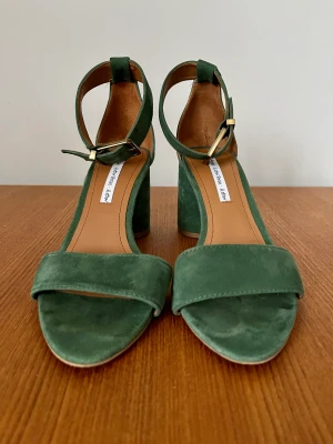 Läcker grön högklackad sammetssko  - I mycket gott skick. I stort sett oanvända. Storlek 38. Passar även något bred fot. 