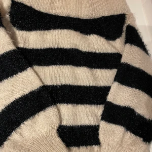 Stickad tröja randig glitter  - Stickad randig tröja från Gina tricot. Svart och beige med glitter. Halsen är båtringning. Gosig mysig och snygg. 