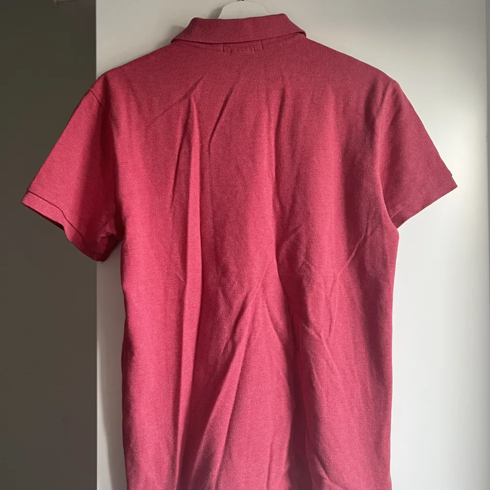Det är en röd/rosa Ralph lauren pike tröja som inte längre används. Det är barnstorlek M.. Skjortor.
