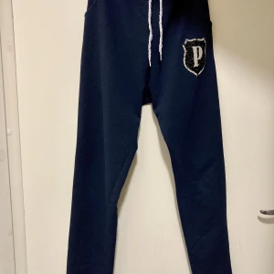 Mörkblå mjuka byxor Stl S/M - PP replika, mjuka byxor, mörkblå med strassdetaljer i svart o silver, fint skick, inget att anmärka på, stl L men passar bättre en S/liten M.