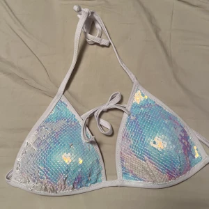 Paljett bikini tezenis  - Säljer en as snygg bikini topp från tezenis! Går att dra paljetterna åt två olika håll 💕 strl 36! Superbra skick som ni ser på sista bilden🥺
