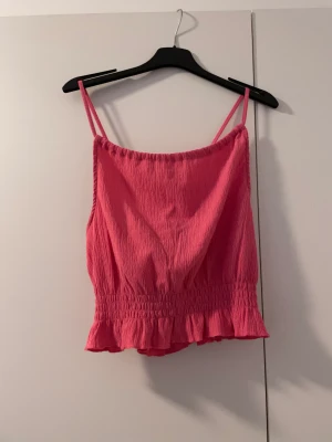 Linne - Rosa linne ifrån Gina tricot. Man kan ändra själv hur toppen ska se ut uppe vid halsen. Korsade band i ryggen och volang nedtill.