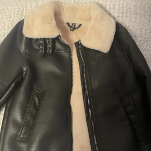 Vinterjacka H&m - Denna jackan är en läderjacka med ett ljusrosa fluff på insidan. Den använd men inte sliten alls, den har utmärkt kvalite och är väldigt värmande. Köpt för 600kr. 
