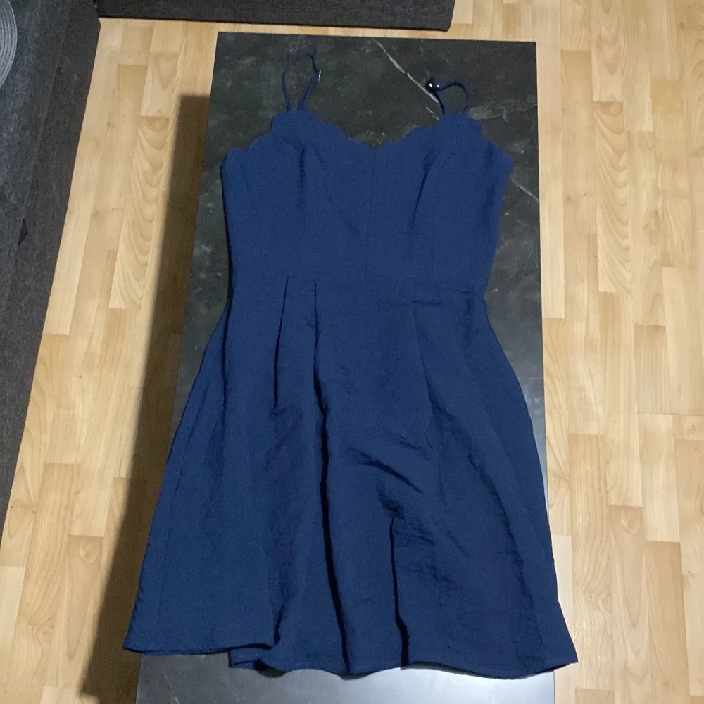 Mörkblå klänning från Nelly i storlek 40 med justerbara axelband, nypris 449kr. Bara använd en gång på en skolavslutning och har sedan dess legat i garderoben. Kan skicka fler bilder om det önskas!. Klänningar.