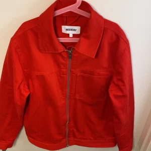 Jeansjacka  - En klarröd jeansjacka, i storlek S. Rak i modellen med en rymlig bröstficka. Knappt använd. 