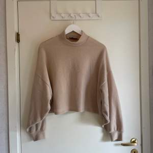 Varm, beige, croppad tröja från Bershka i storlek S. Underbar myströja att glida runt i hemma. Använt men fint skick. 