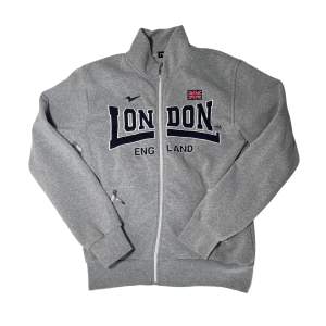 Grå zip up sweater/jacka/tjocktröja med svart tryck ”London” från märket Nas!