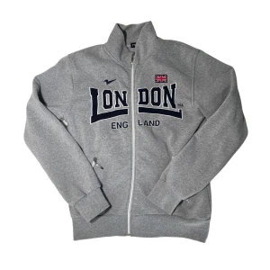 zip up sweater - Grå zip up sweater/jacka/tjocktröja med svart tryck ”London” från märket Nas!