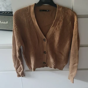 Stickad cardigan - Säljer nu denna fina beiga cardigan för den inte används. Den är jätteskön och kan användas som både tröja eller kofta. Den är knappt använd och stretchig så passar även S. Frakten tillkommer🤎