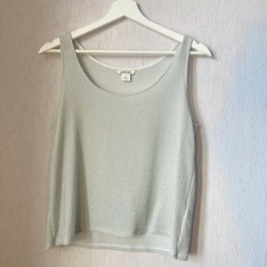 Glittrigt Linne - Glittrigt linne från Monki. I mycket gott skick, inga defekter. Storlek XS, men stor i storleken. 