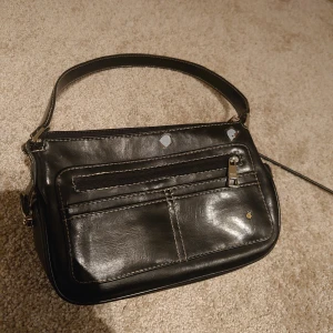 Liten svart hand väska  - Den är liten men får plats med mycket har många fickor och är jätte gullig 