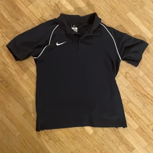Blå Nike Piké  - En blå Nike piké i storlek M, välanvänd och inga defekter förekommer