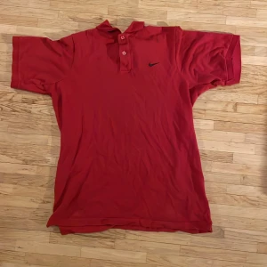Röd Nike Piké  - En röd Nike piké, inga defekter förekommer 