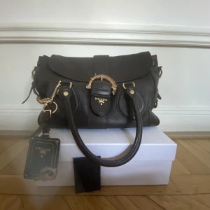 Vintage Prada - Prada Cervo animalier handväska i mörkbrunt läder med guld detaljer. Vintage. Kvitto medföljer