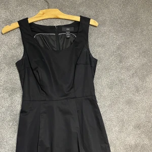 Snäv klänning  - Svart snygg klänning med dragkedja i sidan. Rak, snäv modell.  Stl 36