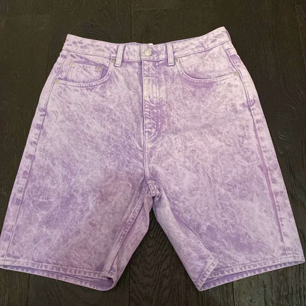 Denim shorts från Weekday i färgen Lilac acid wash. Nyköpta och helt oanvända. Perfekt till sommaren! Strlk 28 som mäter 76cm runt midjan. Skriv gärna vid eventuella frågor, pris kan diskuteras vid snabbt köp.. Shorts.