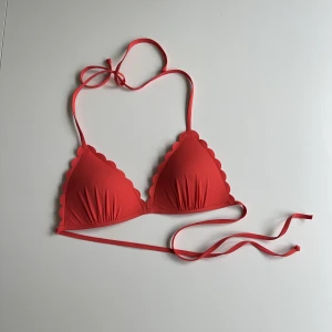 Bikiniöverdel strl 36 - En superfin röd bikiniöverdel med volangkant. Lite tjockare kupa som sitter där den ska. Aldrig använd men jag var lite snabb på att klippa bort lapparna, köpte en likadan i en storlek större istället. 🍒