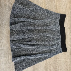 Grå kort kjol - Kort grå kjol från HM med dragkedja bak. Sparsamt använd och mycket fint skick. Säljes pga garderobsrensning.