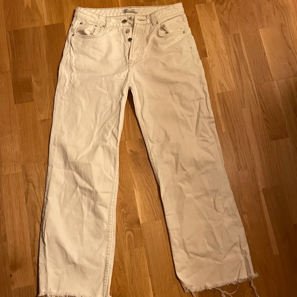 Snygga högmidjade vita jeans med slitning nertill. Jeans & Byxor.