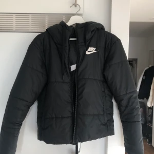Nike jacka  - Sportig dunjacka från Nike. Kan vända den ut och in så man har en nike loggan på ryggen och utan sömmar. Tar Swish