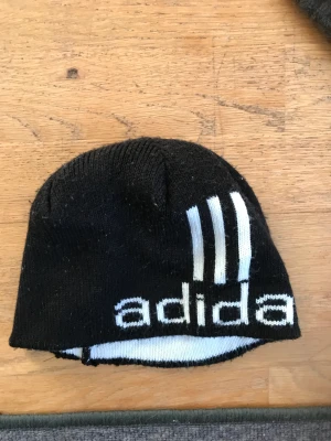 Adidas mössa  - Svart adidas mössa med vit text. Passar både till tjej och kille. 