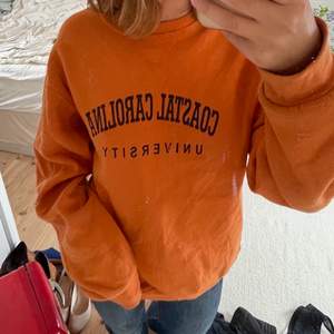 Sweatshirt i stark orange färg med trycket ”coastal Carolina university”. Köpt på en vintagebutik. Härligt material, bra skick. Säljer då jag har för många sweatshirts.