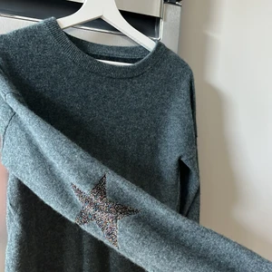 Stickad Zadig  - Zadig tröja med stjärnor på armbågarna. Ena stjärnan gick sönder så har sytt ihop den, lite veckad men inget man tänker på (se sista bilden).  SÄLJER OCKSÅ EN SVART KOFTA MED STJÄRNOR PÅ ARMBÅGARNA, kontakta mig för mer info 