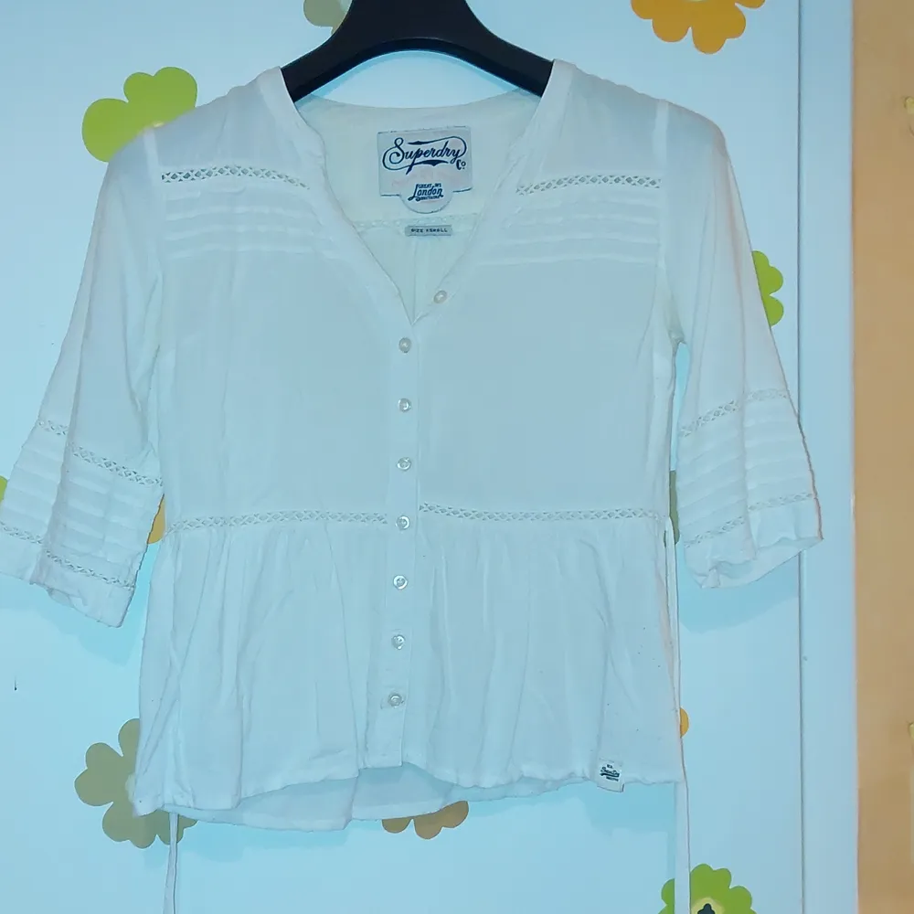 White blouse from SuperDry. Good condition. Adjustable strings on the back.. Blusar.