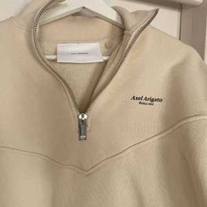 Axel Arigato tröja, xs - Inköpt i våras. Säljer en beige tröja från Axel Arigato, väldigt skön men som ändå inte kommer till användning.  Sparsamt använd 
