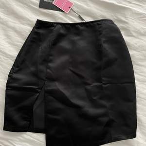 Svart satin aktig kjol med slits från Pretty little thing i strl 34🖤 Aldrig använd och prislappen kvar. Säljer för 100kr+frakt