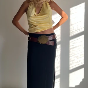 Svart Midi kjol - Svart midikjol med slits på kanten! Kjolen är från BikBok och jag har endast provat den (bilderna). Alla taggar är kvar. Säljes pga har en exakt likadan i annan storlek. Originalpris: 399kr