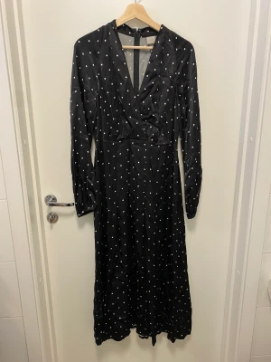 Midiklänning hm - Svart och vit prickig klänning från HM. Använd en gång endast. Satin. Superfin både i kallare klimat med strumpbyxor eller mer vår/sommar.💄